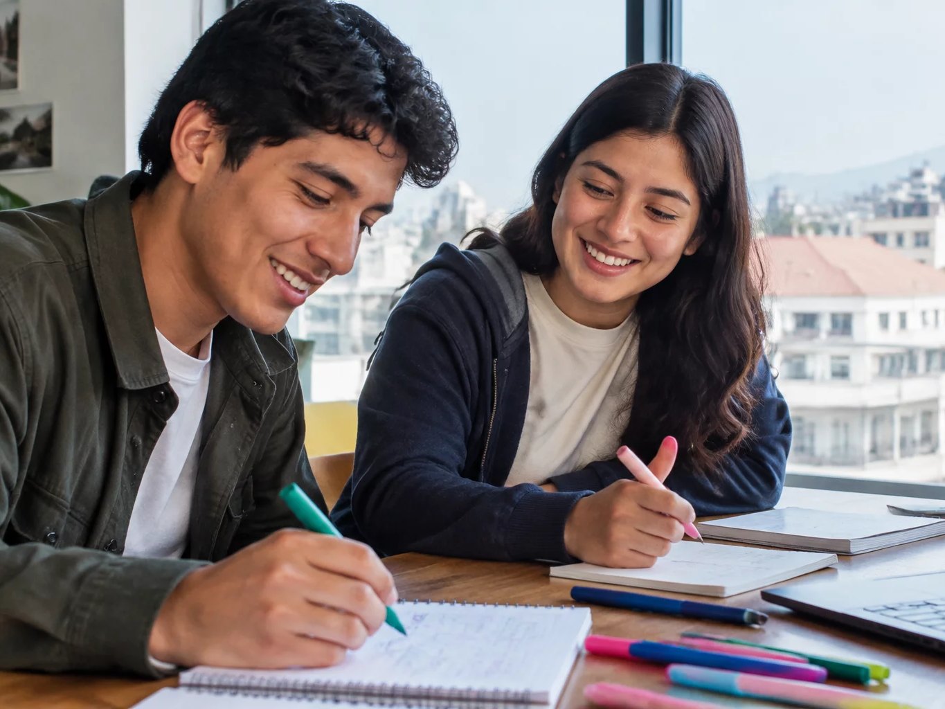 Dos personas preparando la ronda con cuadernos y plumones de colores